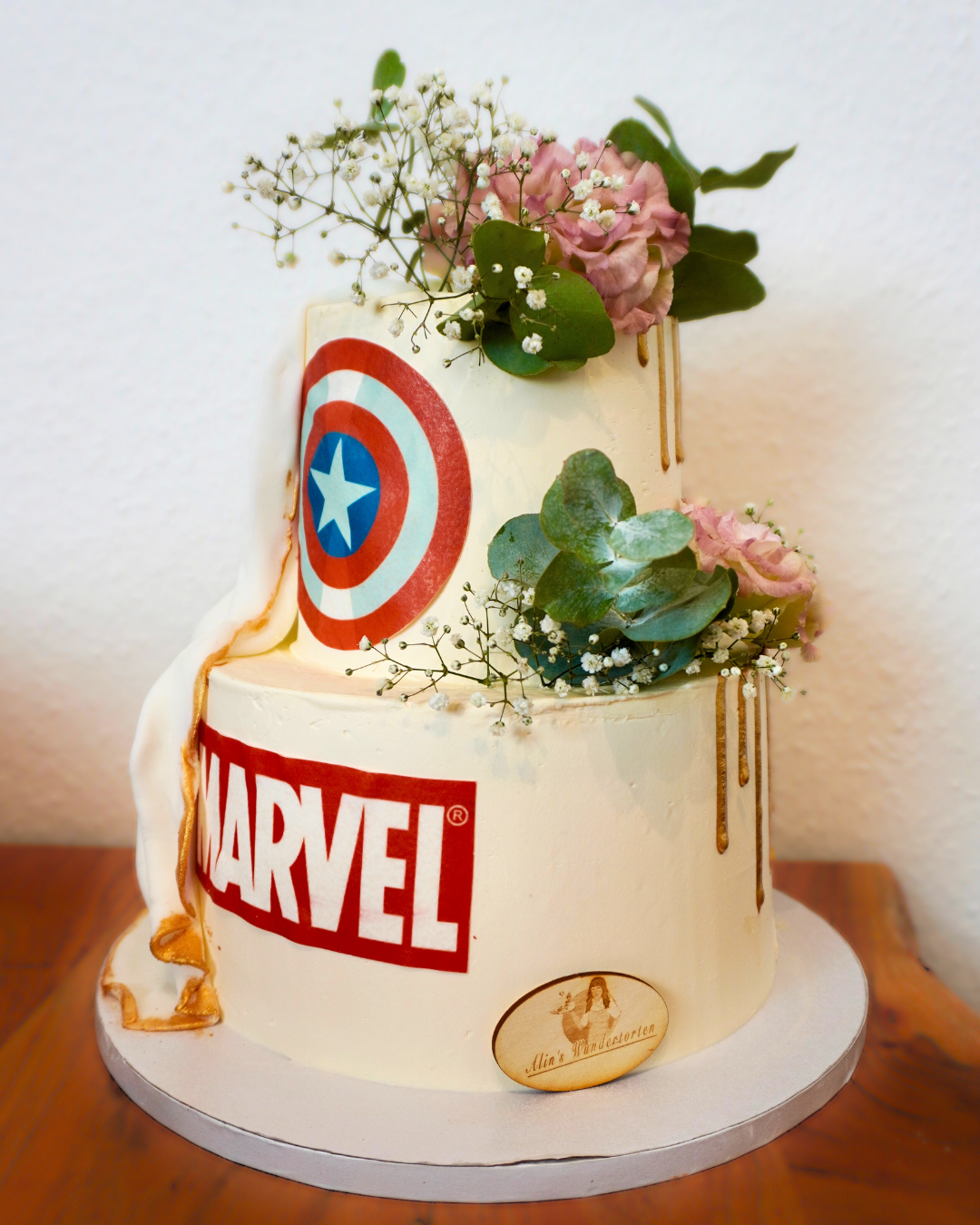 Ein Kuchen mit dem Captain America-Logo, farbenfroh dekoriert und auf einem festlichen Tisch präsentiert
